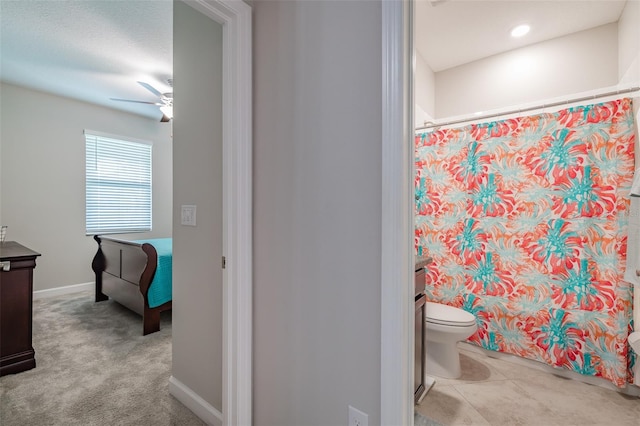 bathroom with curtained shower, ceiling fan, toilet, and vanity