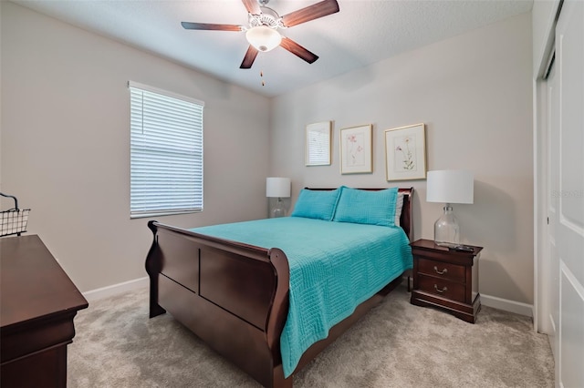 bedroom featuring a textured ceiling, ceiling fan, and light carpet