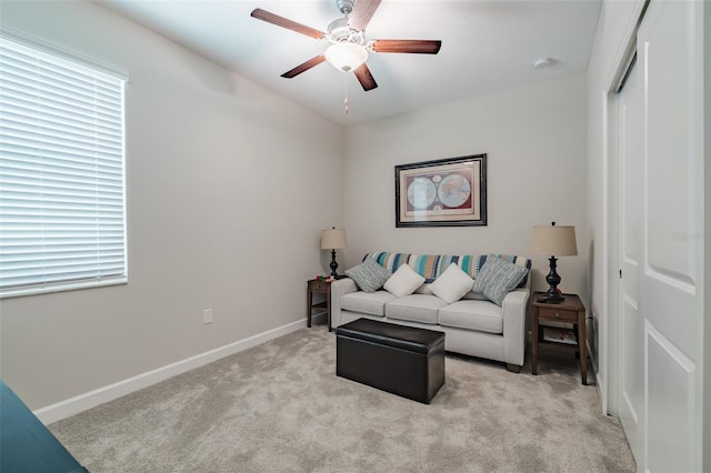 living room featuring ceiling fan, plenty of natural light, and light carpet