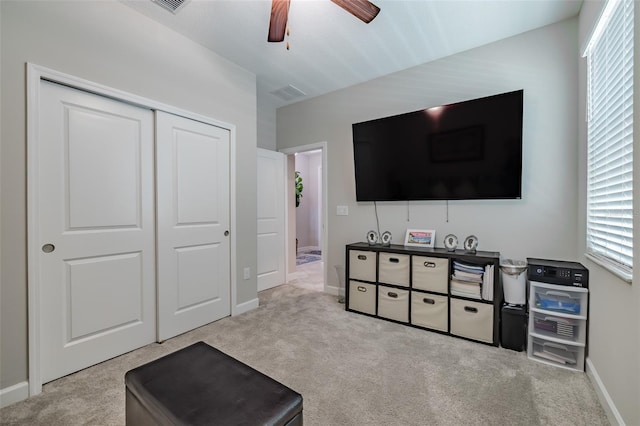 interior space featuring ceiling fan and light carpet