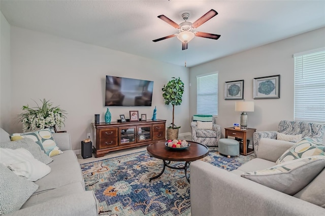 living room with plenty of natural light, ceiling fan, and carpet flooring