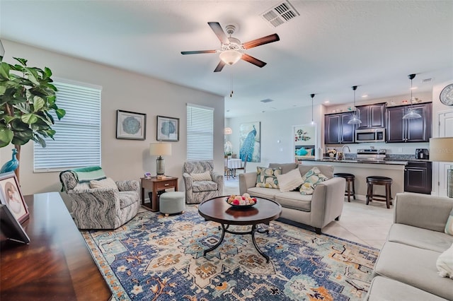 living room featuring ceiling fan and light tile patterned floors