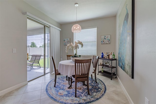 tiled dining room featuring an inviting chandelier