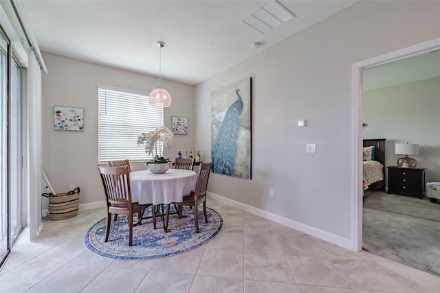 carpeted dining area featuring an inviting chandelier