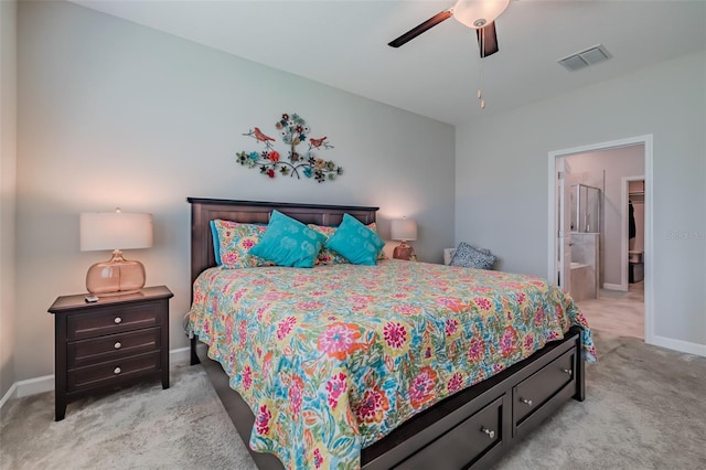 bedroom with ceiling fan, connected bathroom, and light carpet