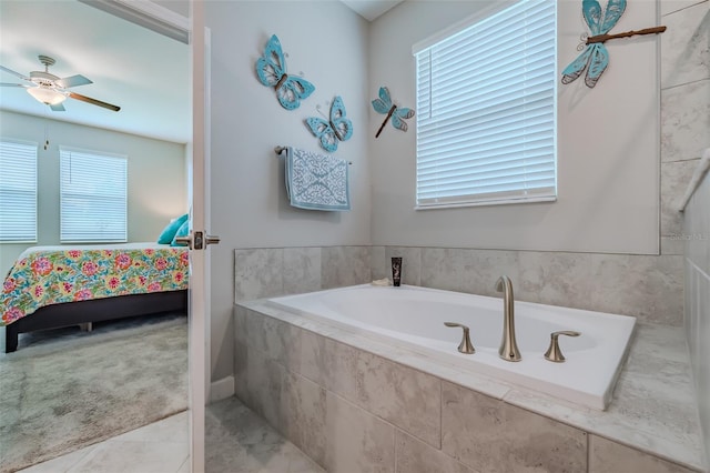 bathroom with ceiling fan and tiled bath