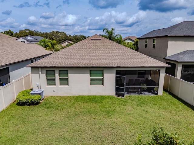 back of house with a sunroom, a yard, and central air condition unit