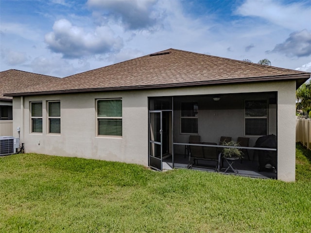 rear view of house featuring cooling unit, a yard, and a sunroom