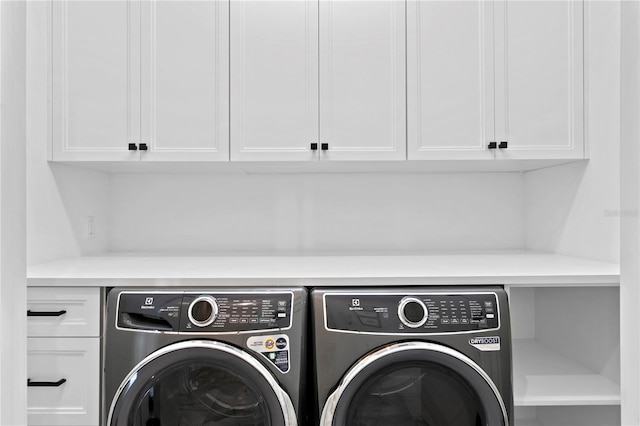 washroom featuring cabinets and washing machine and dryer