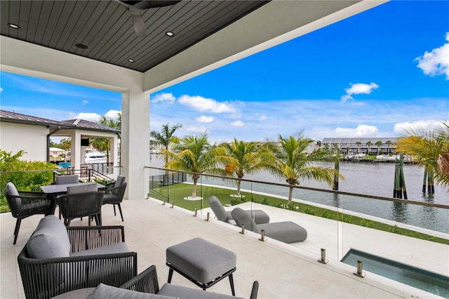 view of patio with ceiling fan and a water view