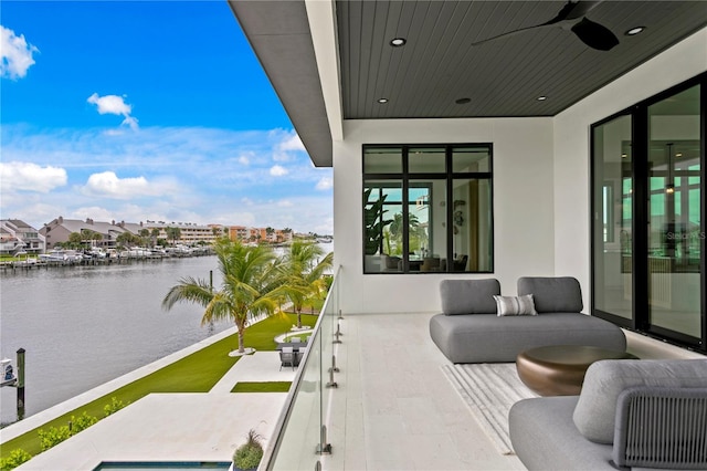 balcony featuring ceiling fan and a water view