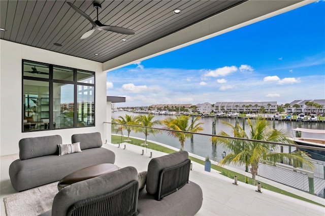 balcony featuring ceiling fan and a water view