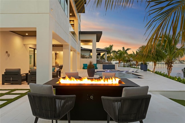 patio terrace at dusk featuring an outdoor fire pit