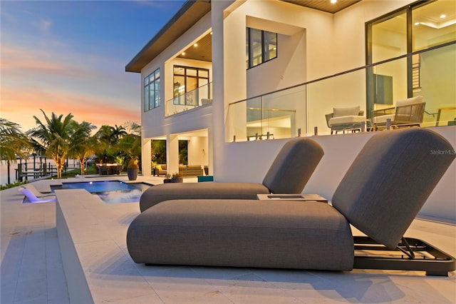 patio terrace at dusk featuring an outdoor living space