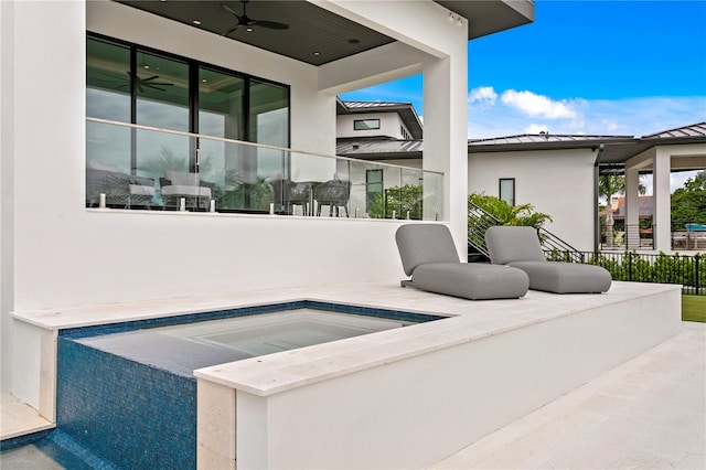 view of patio / terrace featuring ceiling fan and a jacuzzi