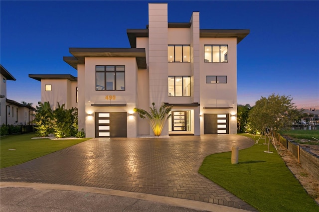 contemporary home featuring a yard and a garage