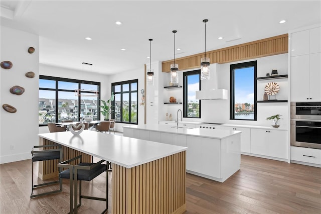 kitchen featuring a large island, sink, and white cabinets