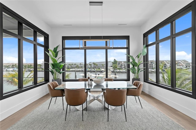 sunroom featuring a water view and a wealth of natural light