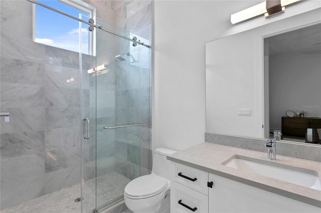 bathroom featuring vanity, toilet, and a shower with door