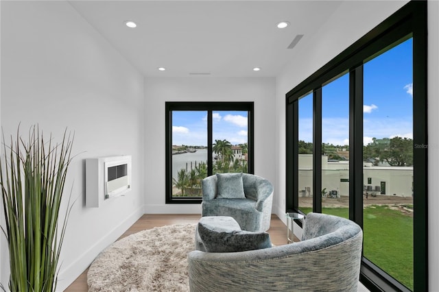 sitting room featuring light hardwood / wood-style floors and a water view