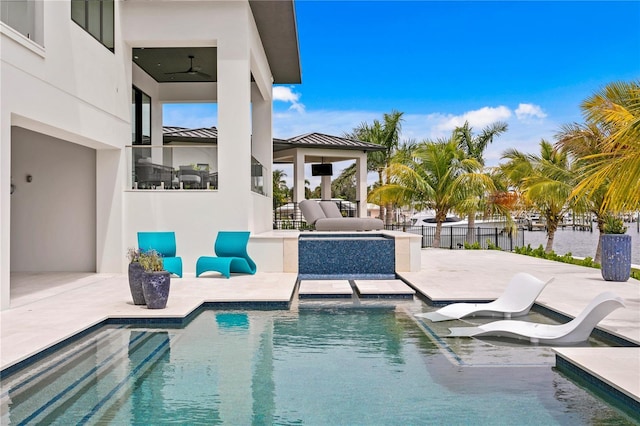 view of pool with ceiling fan and a patio