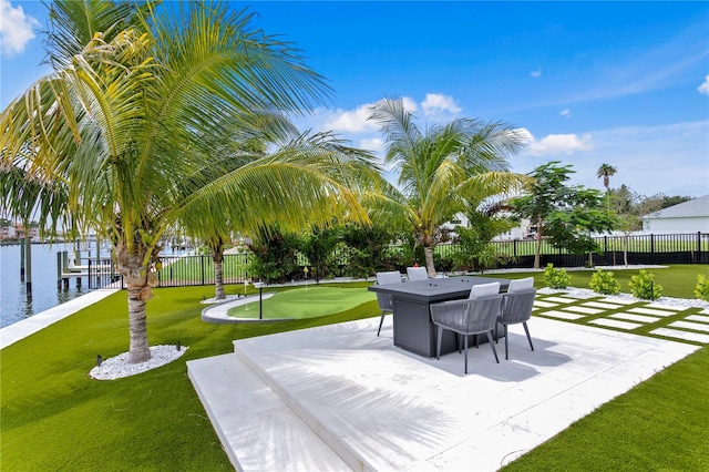 view of property's community featuring a patio area, a water view, a yard, and a dock