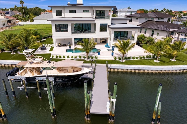 rear view of property featuring a patio area, a balcony, and a water view