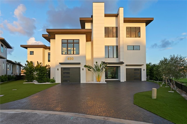 contemporary house with a front yard and a garage