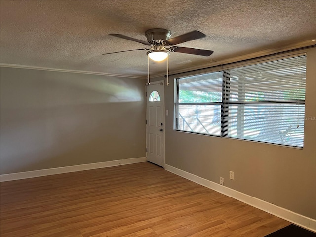 entrance foyer with ceiling fan, ornamental molding, a textured ceiling, and hardwood / wood-style floors