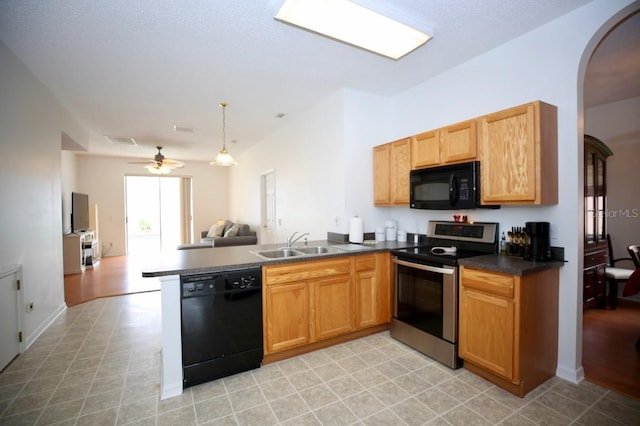 kitchen with sink, kitchen peninsula, black appliances, decorative light fixtures, and ceiling fan