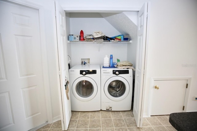 laundry room with washer and clothes dryer and light tile patterned floors