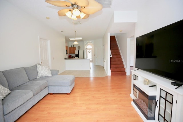 living room with light hardwood / wood-style floors and ceiling fan