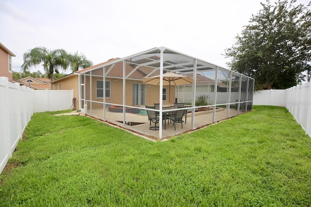 rear view of house featuring a fenced in pool, a lawn, a patio, and glass enclosure