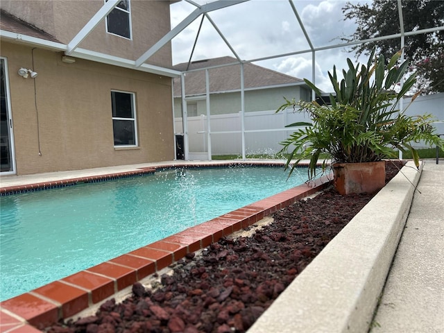 view of swimming pool featuring a lanai