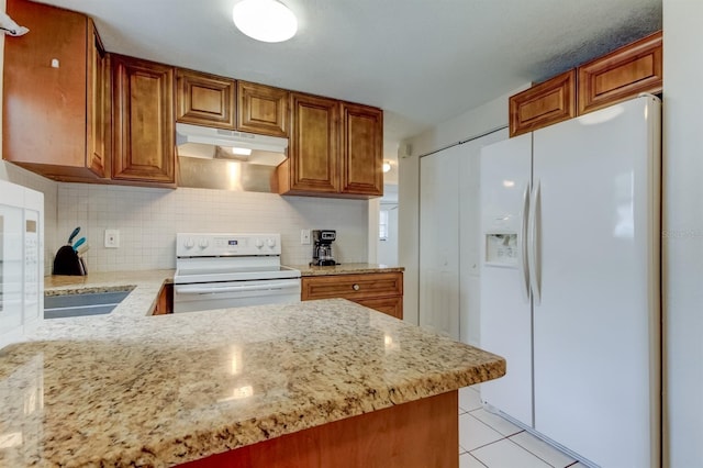 kitchen with white appliances, tasteful backsplash, light tile patterned floors, kitchen peninsula, and light stone countertops