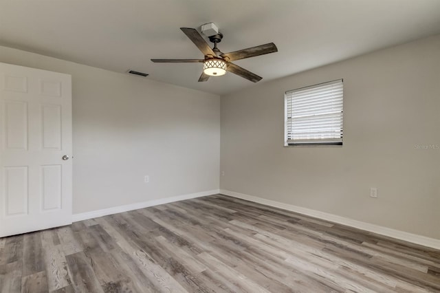 spare room with ceiling fan and light wood-type flooring