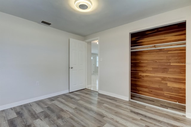 unfurnished bedroom featuring light hardwood / wood-style flooring and a closet