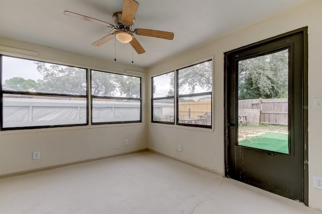 unfurnished sunroom featuring ceiling fan