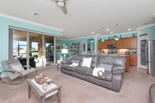 living room featuring ornamental molding, ceiling fan, and light colored carpet