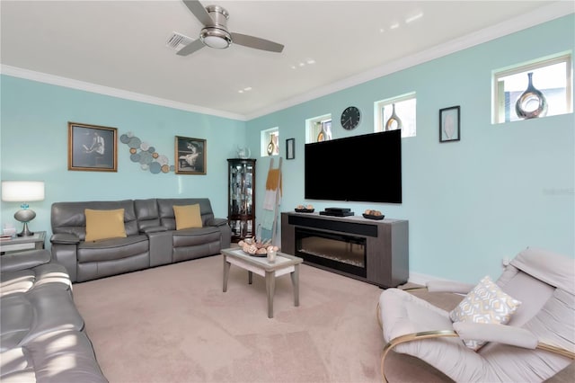 carpeted living room with ceiling fan and crown molding