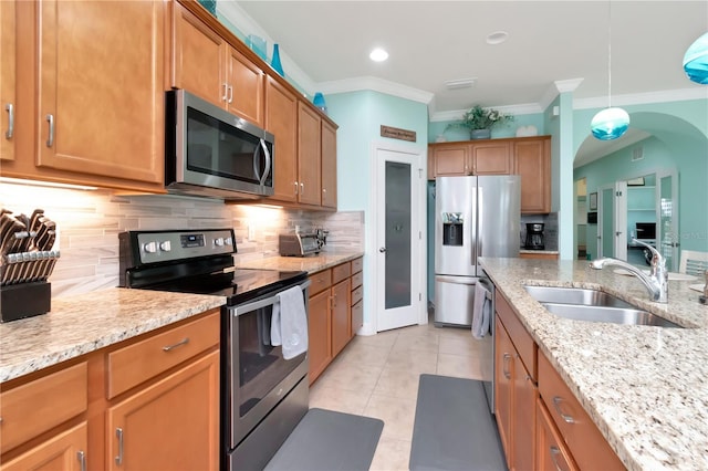 kitchen featuring hanging light fixtures, sink, appliances with stainless steel finishes, light stone countertops, and decorative backsplash