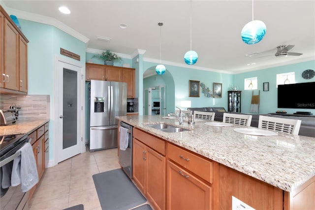 kitchen with pendant lighting, a kitchen island with sink, sink, stainless steel appliances, and ceiling fan