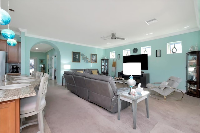 carpeted living room featuring ceiling fan and ornamental molding