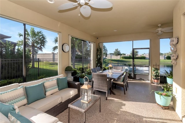 sunroom / solarium featuring a healthy amount of sunlight, a water view, and ceiling fan