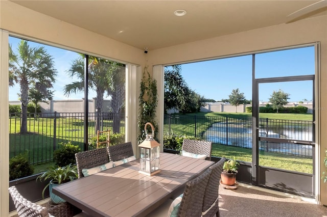 sunroom featuring a water view and a healthy amount of sunlight