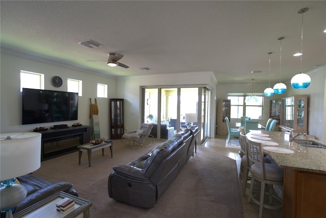 6342 Kenava Loop, Palmetto, FL 34221 - living area with crown molding, a ceiling fan, and light colored carpet