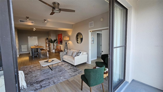 living room featuring ceiling fan and wood-type flooring