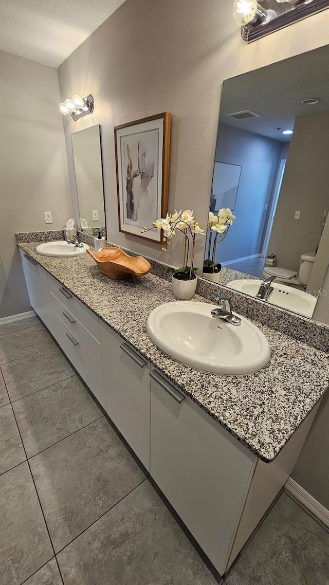 bathroom featuring tile patterned flooring, vanity, and toilet