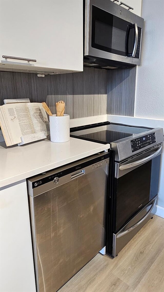 kitchen featuring appliances with stainless steel finishes and light hardwood / wood-style flooring