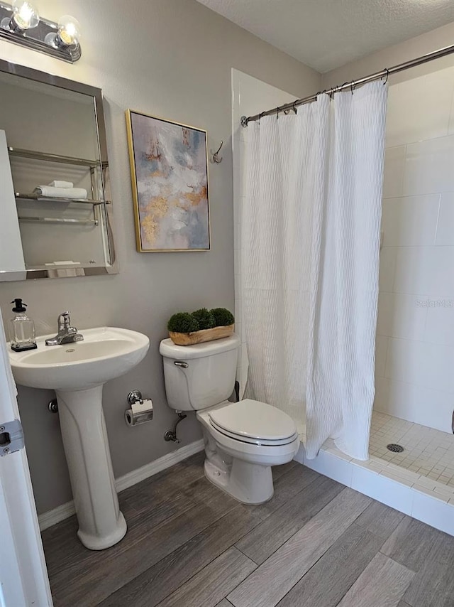 bathroom with a shower with curtain, toilet, and sink